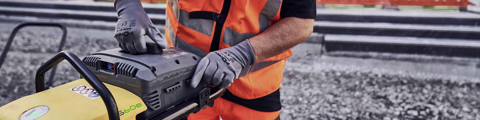 man changing battery at rammer