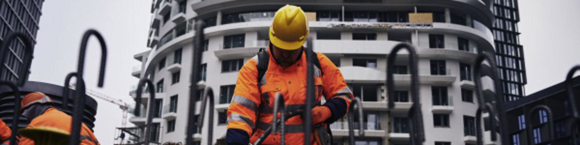 Un trabajador de la construcción en una obra compactando hormigón con un vibrador interno de Wacker Neuson.