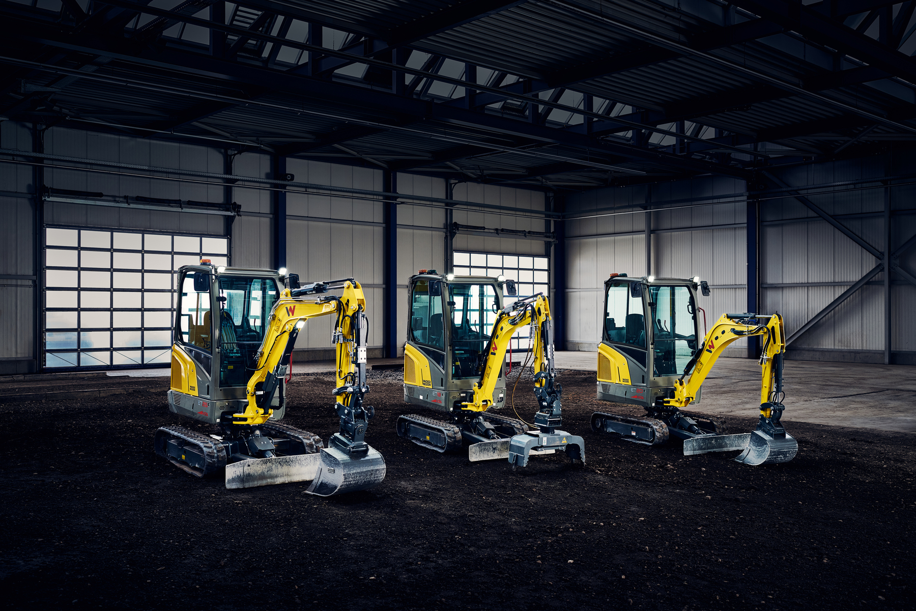 Miniexcavadoras expuestas en una gran nave